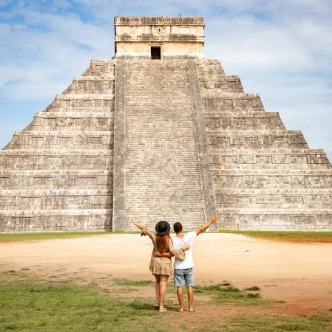 A couple admiring the view of the majestic Kukulkan pyramid during their Chichen Itza Private Tour.