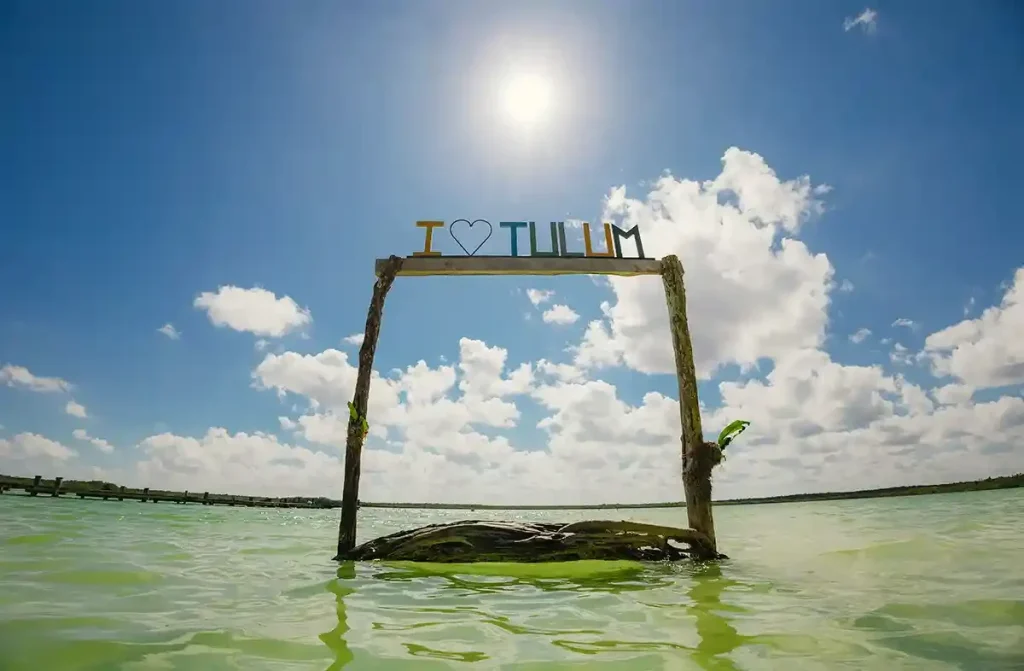 I Love Tulum sign above water in Kaan Luum Lagoon under a sunny sky.