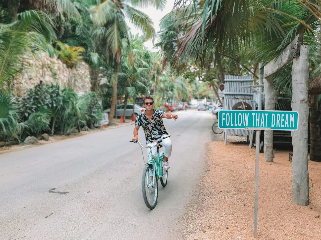 Tourist riding a bicycle in Tulum hotel area.