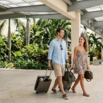 Couple arriving at Tulum hotel, walking with luggage.