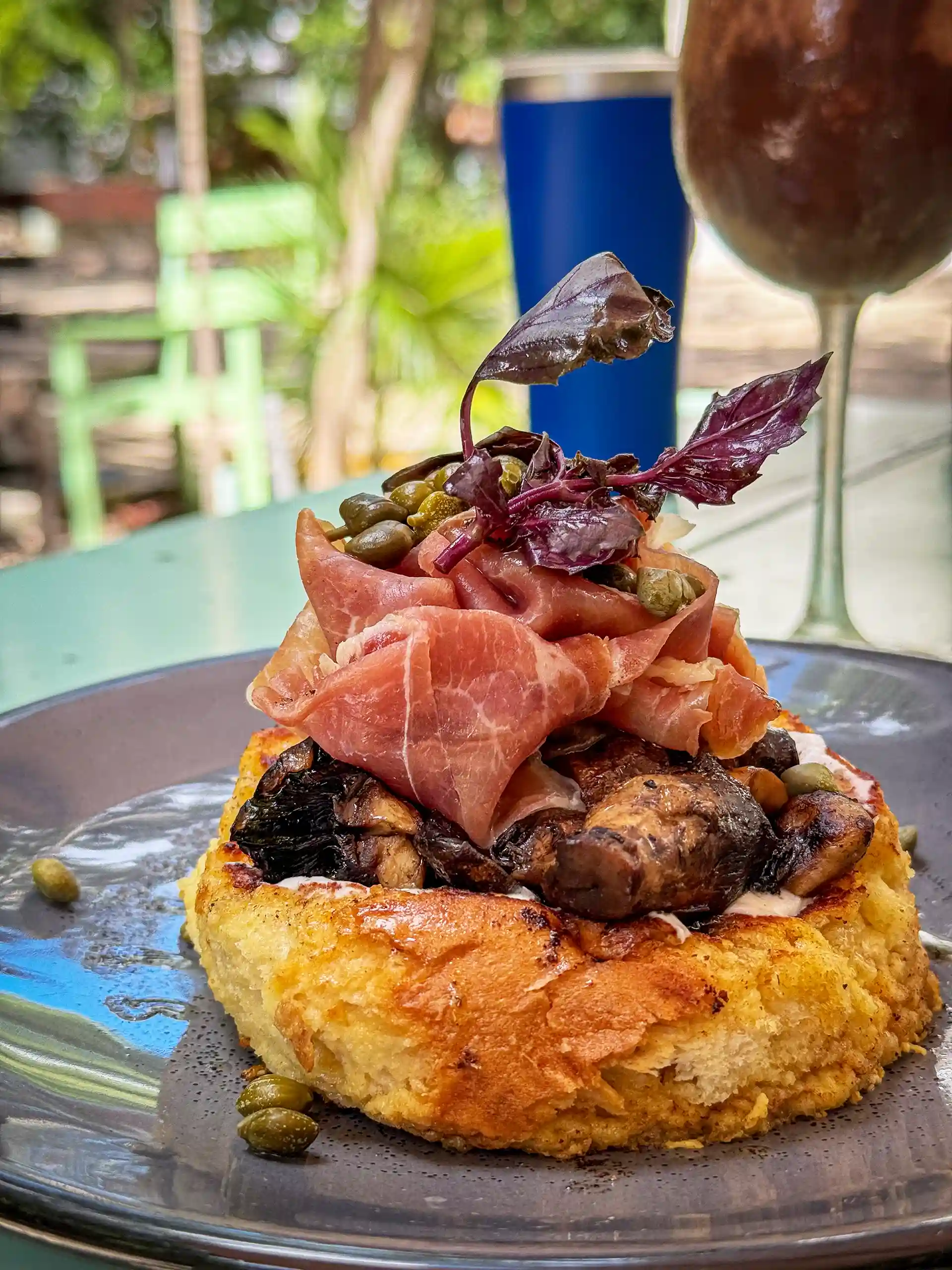 Gourmet salmon pancake topped with capers and herbs.