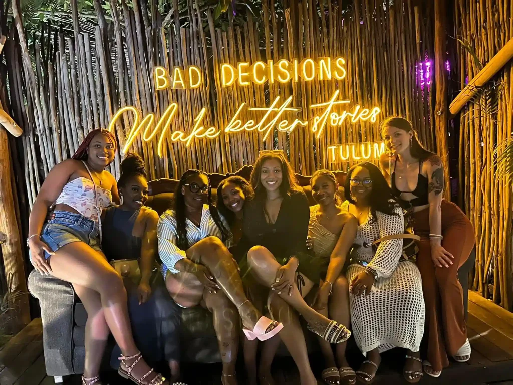 Women sitting together on a large couch at a Tulum nightclub