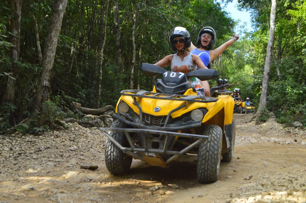 Two girls riding an ATV in the jungle during an adventure tour in Tulum