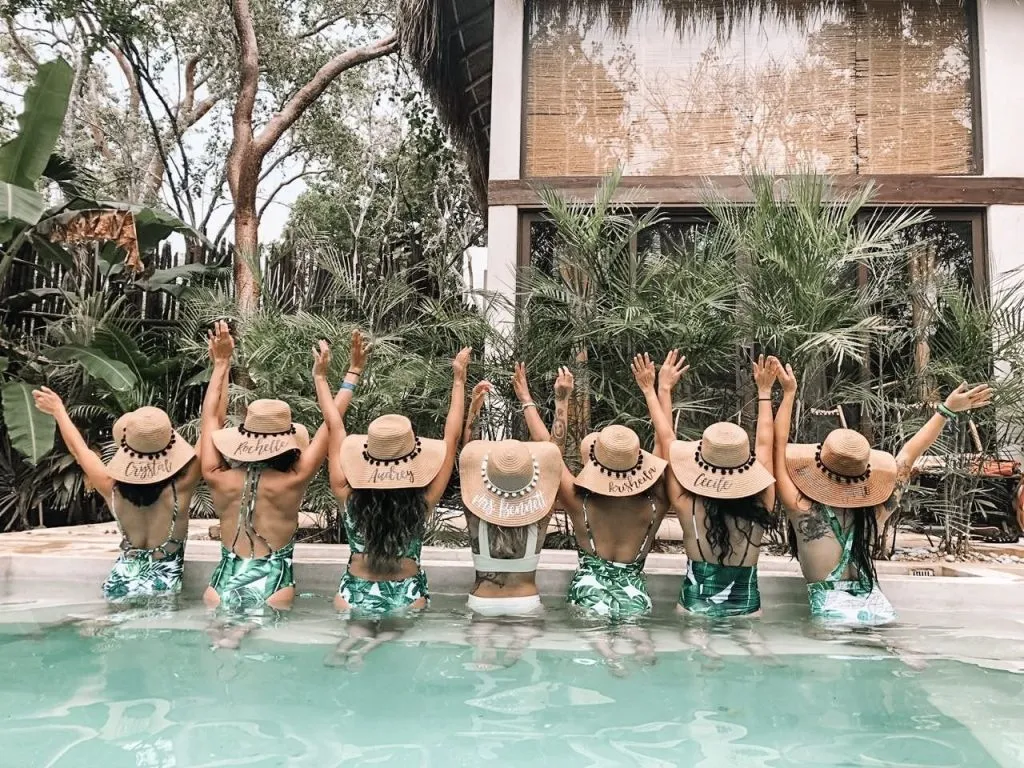 Women posing from behind in a pool enjoying a bachelorette party