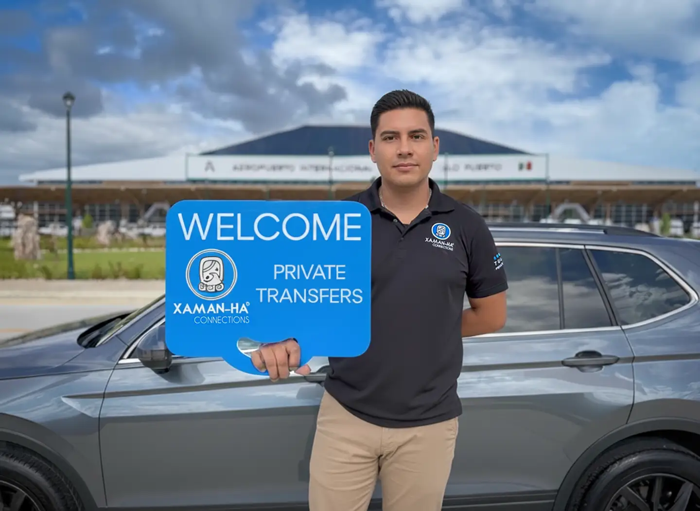 Private driver from Xaman-Ha Connections holding a welcome sign for private transfers at Tulum Airport.
