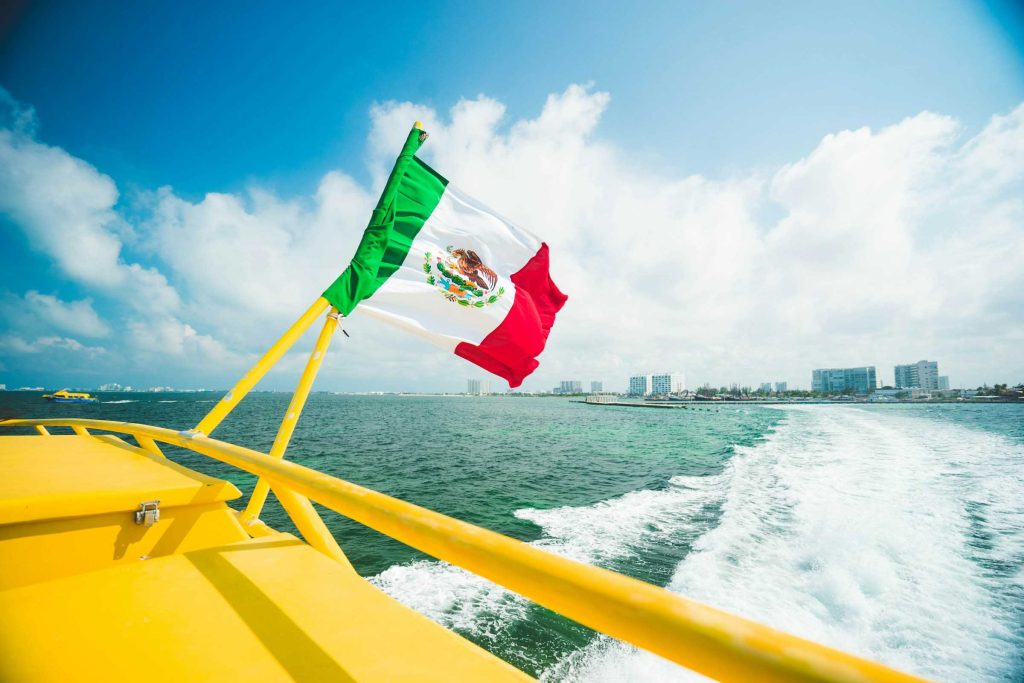Mexican flag on a boat sailing in Cancun Bay.