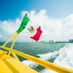 Mexican flag on a boat sailing in Cancun Bay.
