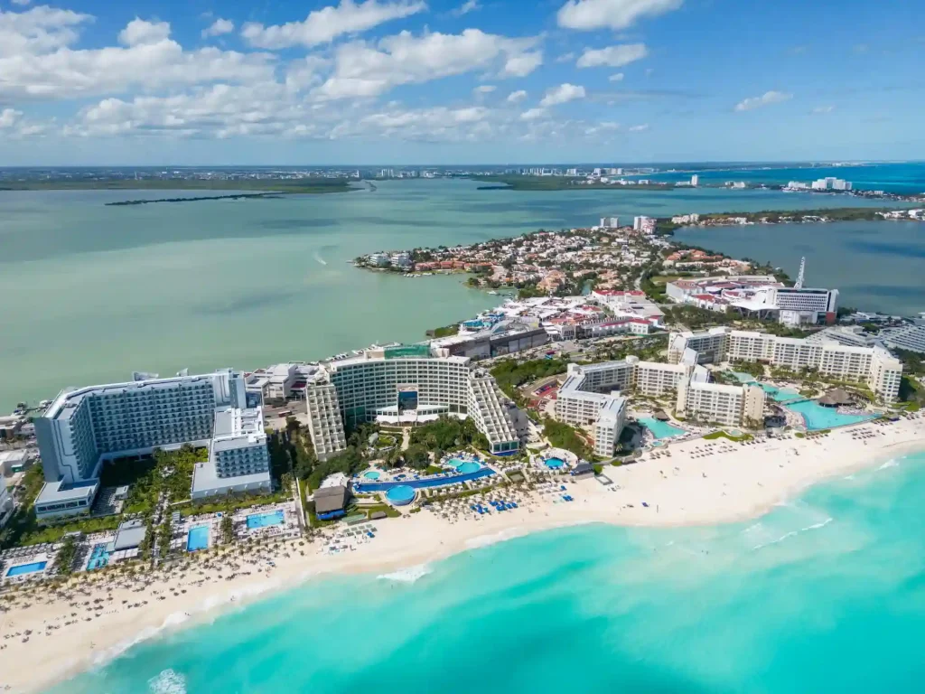 Cancun hotel zone during morning time with beachfront hotels and clear skies.