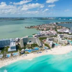 Cancun hotel zone during morning time with beachfront hotels and clear skies.