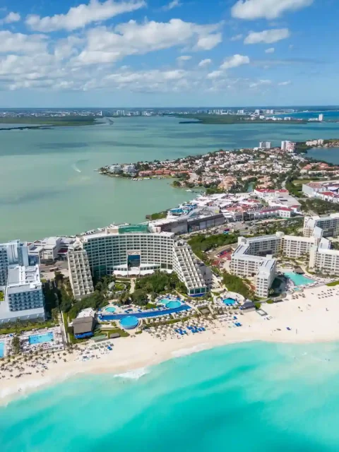 Cancun hotel zone during morning time with beachfront hotels and clear skies.
