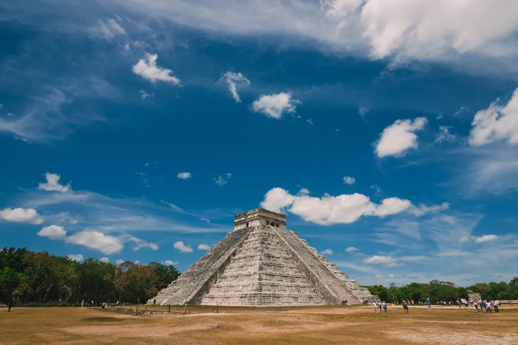 The iconic Kukulkan Pyramid at Chichen Itza, a UNESCO World Heritage site in Yucatan, Mexico, under a bright blue sky.