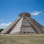 Temple of Kukulcán at Chichen Itza, a large stepped pyramid under a clear blue sky, showcasing ancient Mayan architecture in Yucatán, Mexico.