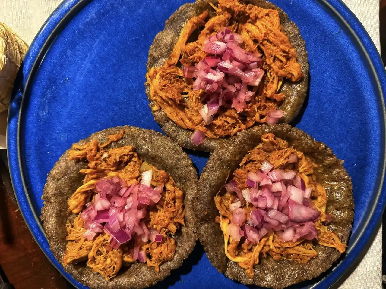 Cochinita pibil sopes served on blue corn tortillas in Valladolid.