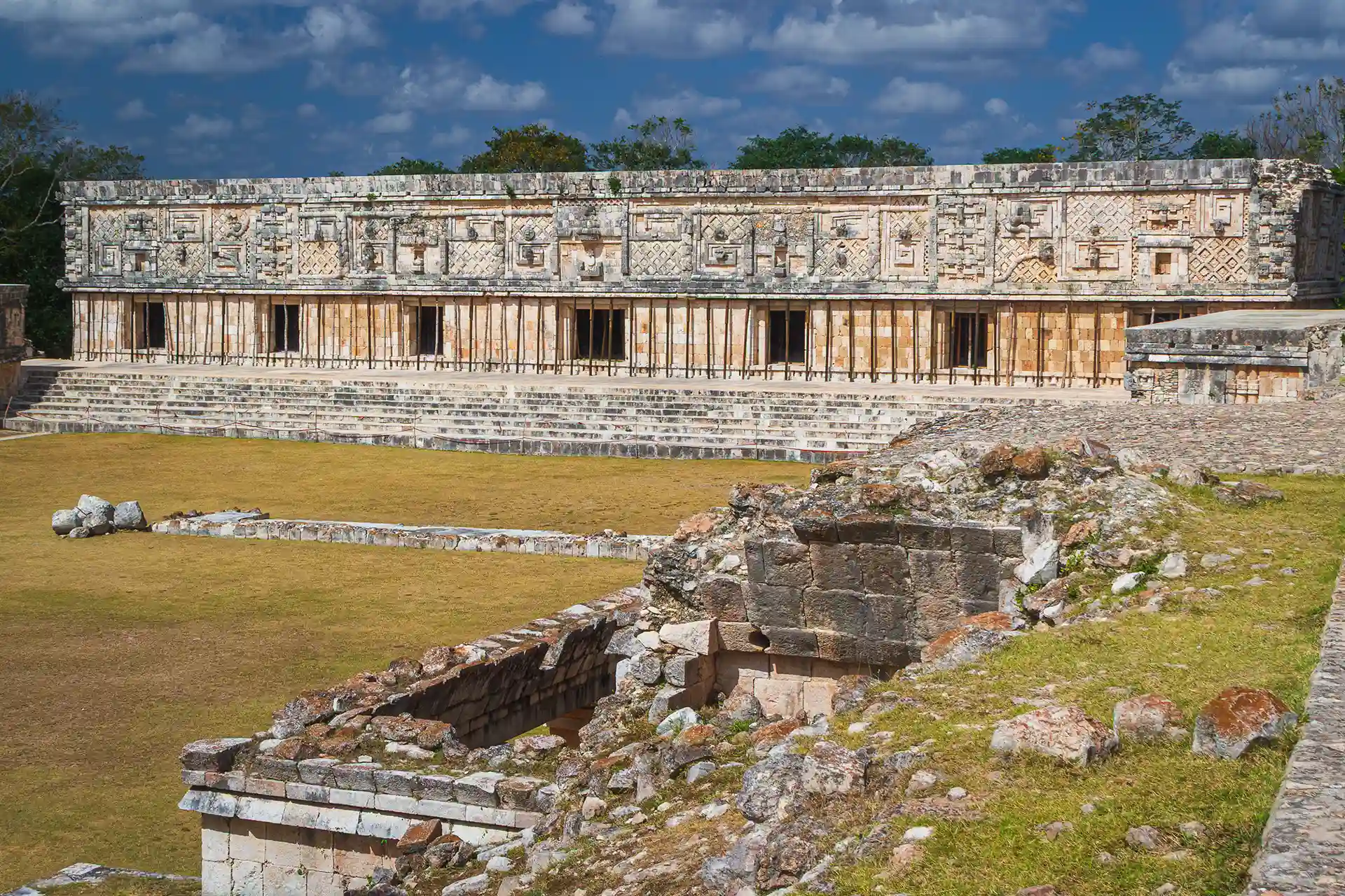 Panoramic view of the Nunnery Quadrangle at Uxmal, an ancient Mayan structure with intricate stone carvings.