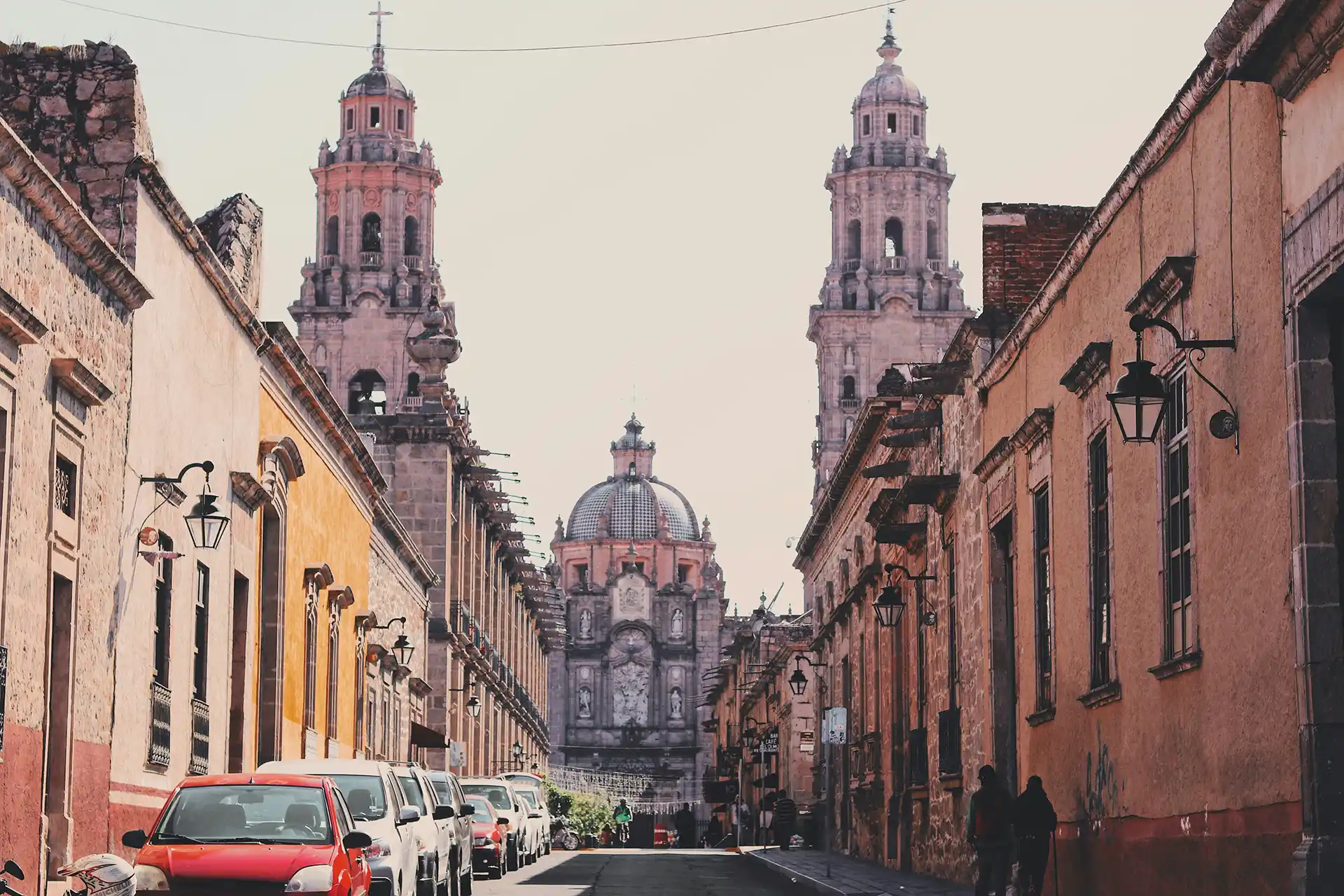 Colonial street in Valladolid, Mexico, with historic buildings and a church in the background.
