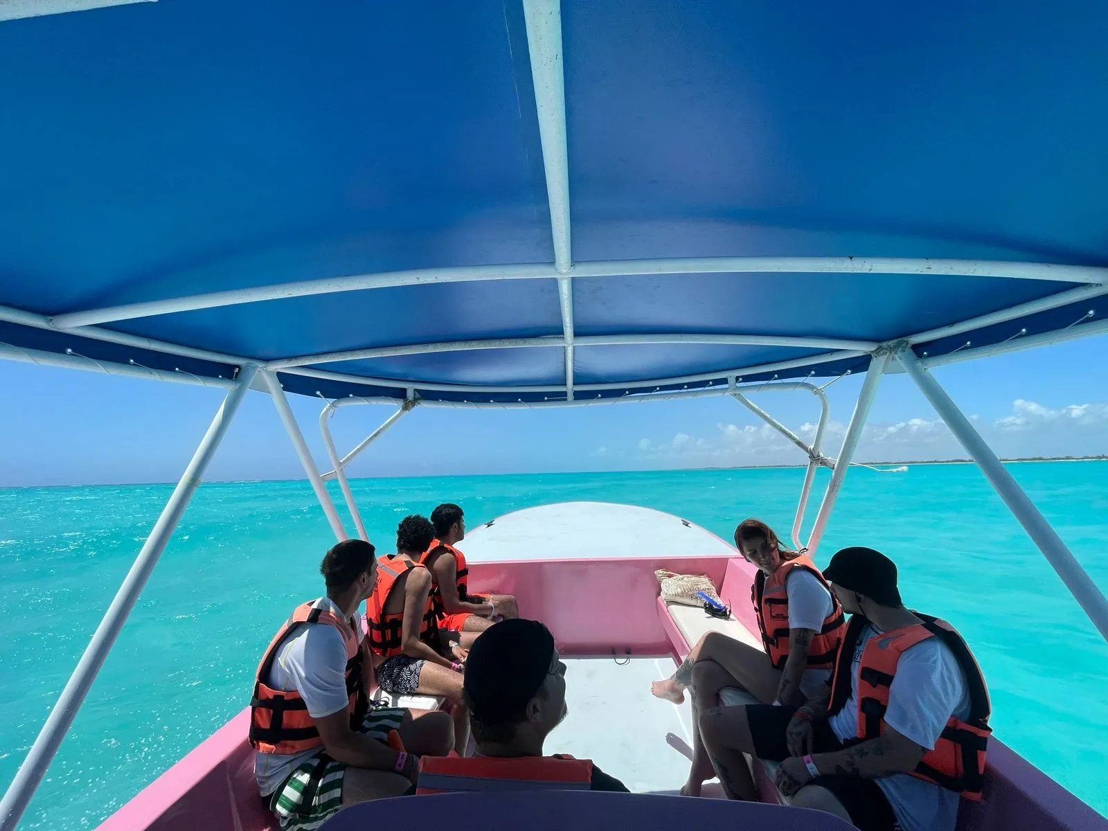 Tourists on a boat in turquoise waters, heading out for a whale shark tour experience.