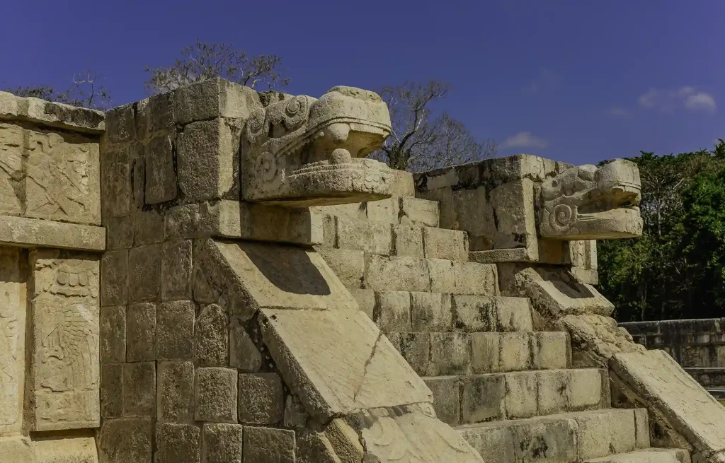 Stone serpent head sculptures at the Temple of Kukulkan in Chichen Itza, representing ancient Maya mythology.