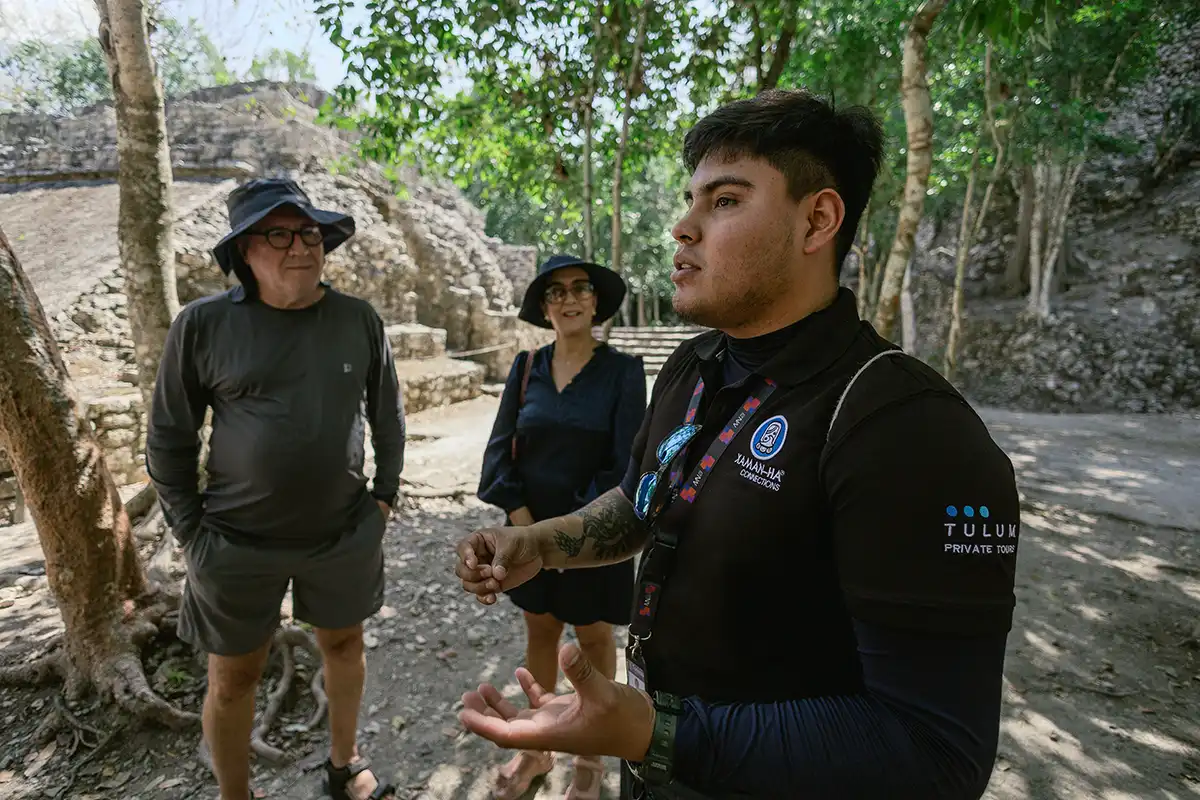 A private tour guide explains Coba to visitors.