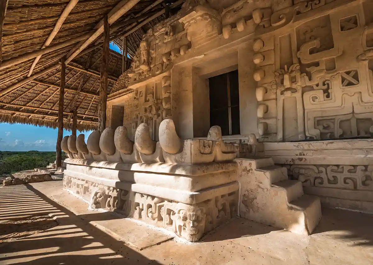 Intricate stucco carvings and jaguar sculpture at Ek Balam ruins.