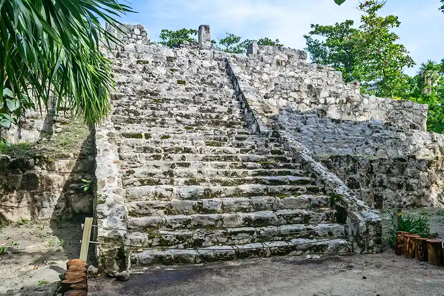Ancient Mayan stone temple with a central staircase at San Miguelito ruins near Cancún.