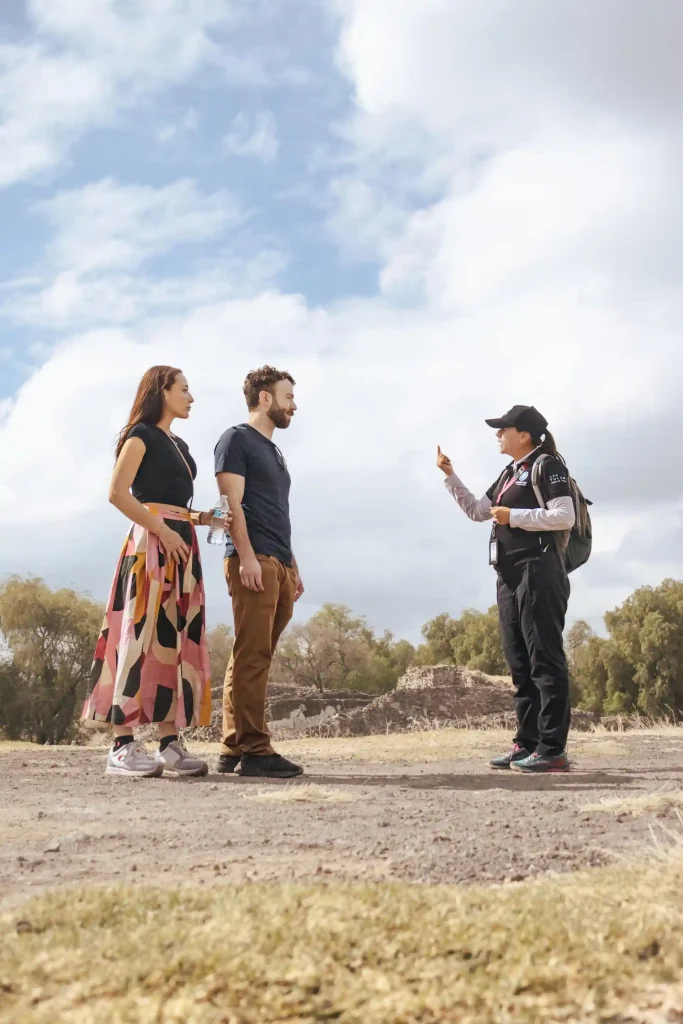 Couple listening to a private tour guide explaining Mexico City’s historical site during a guided experience