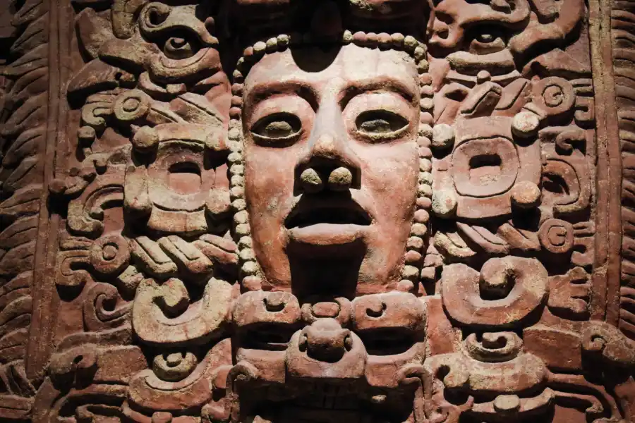 Close-up of Mayan carved stone face exhibited at the Anthropology Museum in Mexico City.