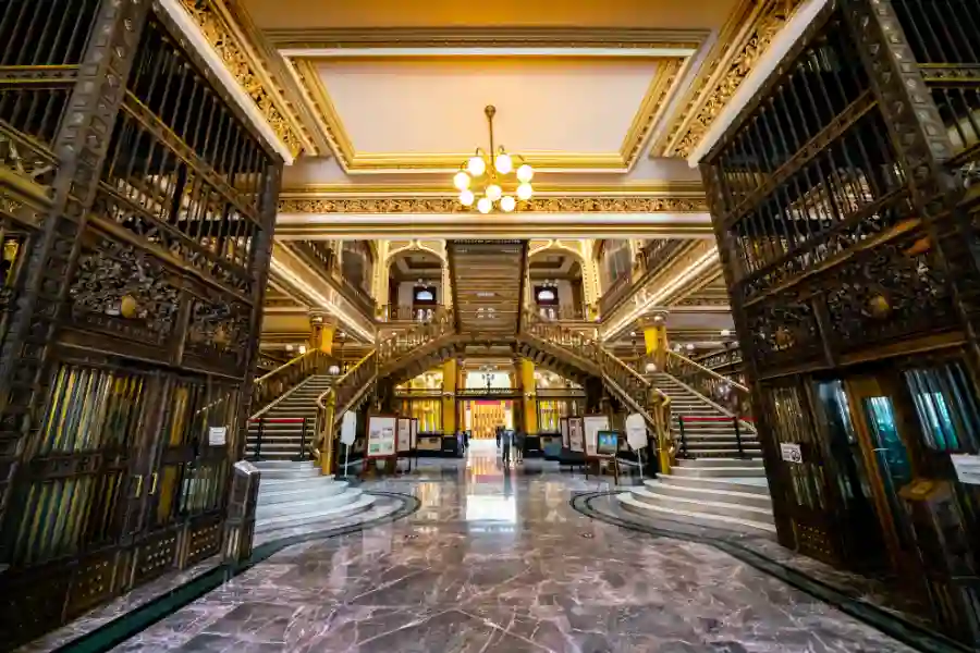 Ornate golden staircases and ironwork inside the historic Palacio Postal in Mexico City.