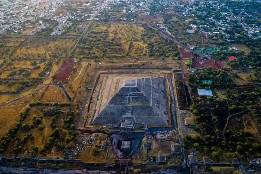 A stunning aerial shot of Teotihuacán’s massive pyramids and urban layout, surrounded by countryside and modern settlements.