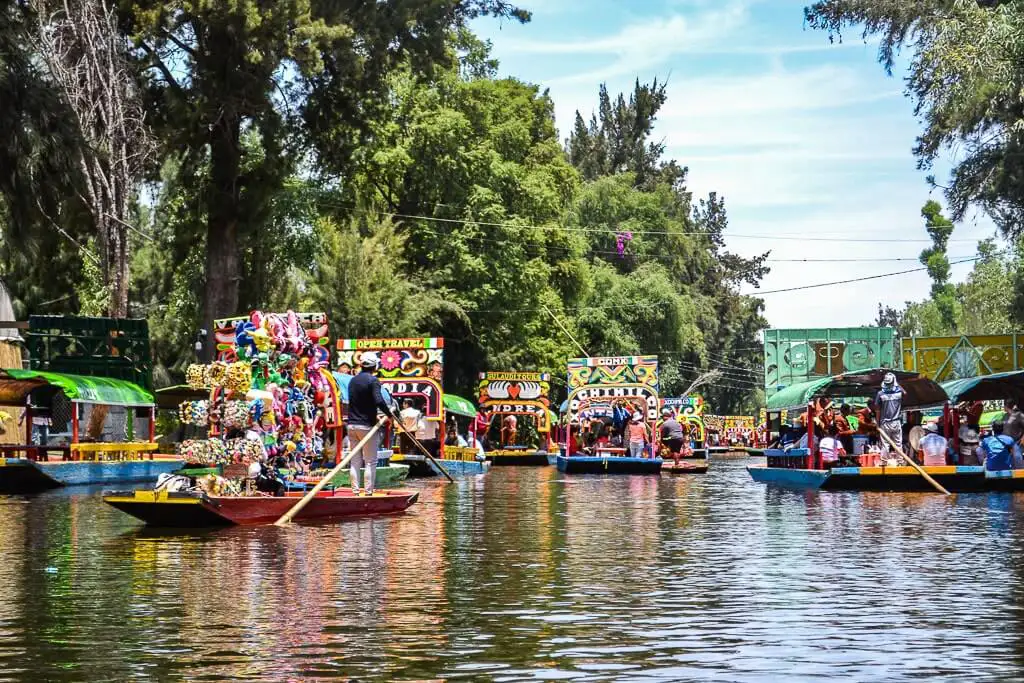 Various trajineras sailing through the canals of Xochimilco.