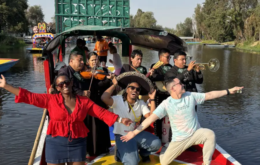 Travelers enjoying a Xochimilco private boat tour with mariachi musicians on a colorful trajinera.