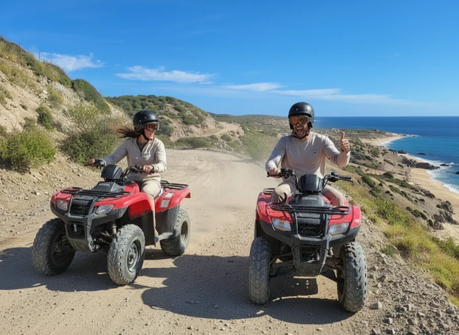 Couple riding red ATVs on a coastal dirt trail overlooking the Sea of Cortez in Cabo San Lucas.