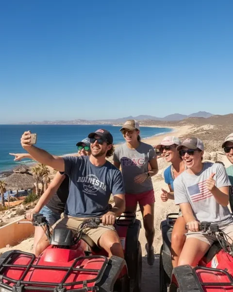 Group of friends taking a selfie on ATVs at a coastal overlook during a Cabo ATV tour.