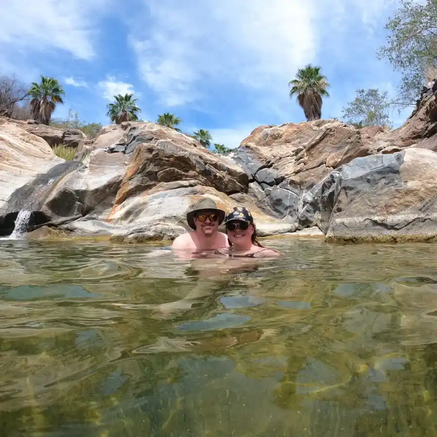 Couple swimming in crystal-clear pool in Fox Canyon.