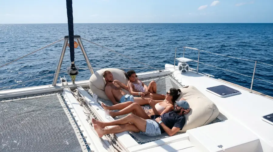 Guests relaxing on the front deck of a luxury private catamaran sailing tour in Cabo San Lucas.