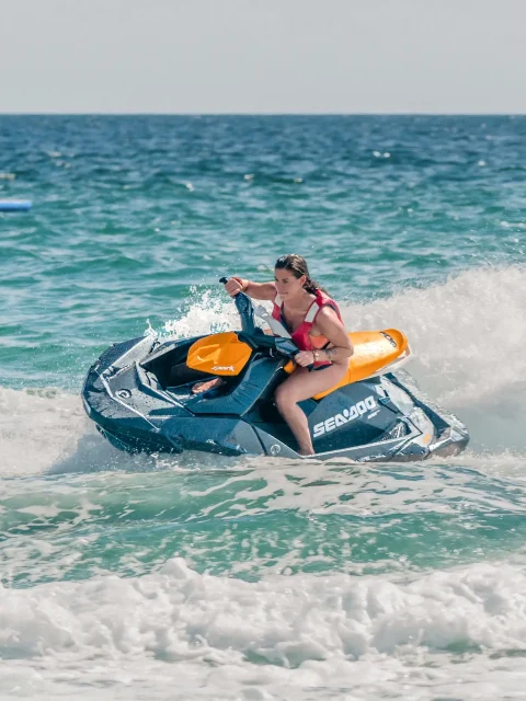 Jet ski adventure in Cabo San Lucas with rider speeding across the Sea of Cortez near the beach.