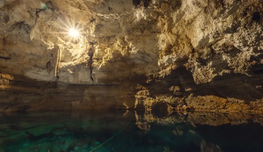 Underground cenote Cho-Ha near Cobá area, crystal-clear water and stalactites.