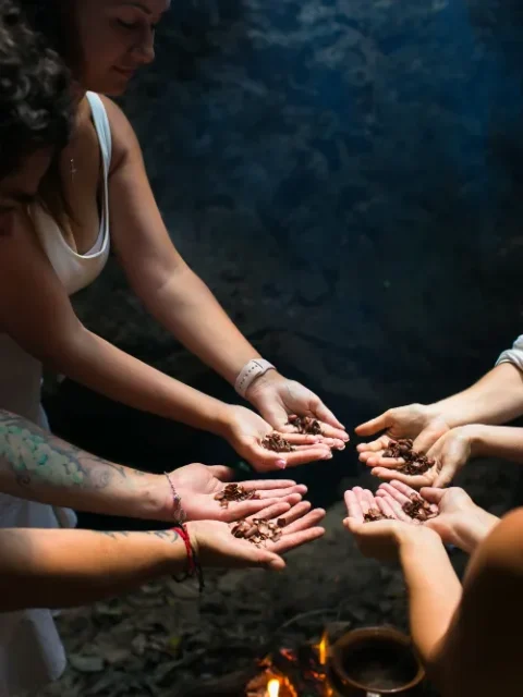 A group of people with a shaman holding cacao beans.