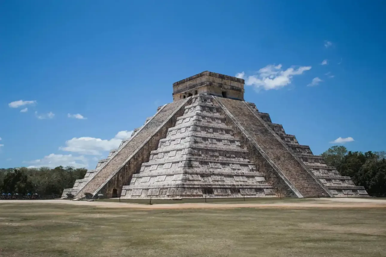 Temple of Kukulcan at Chichen Itza, a large stepped pyramid under a clear blue sky.