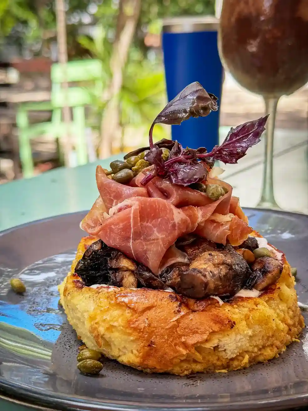 Gourmet salmon pancake topped with capers and herbs.